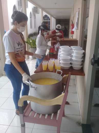  Voluntária prepara o suco que acompanha as refeições