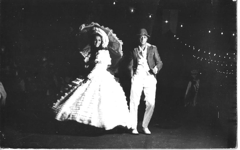 Sandra Castiel e Dilson Machado, na passarela, olhos nos olhos, dirigidos por Marise Castiel. Sóbrios, discretos, elegantes, belíssimos, faziam praticamente o apogeu, o ápice, o luxo monumental naquela ópera, que se apresentava na avenida a céu aberto em Porto Velho, não no palco do Teatro Amazonas. Aplausos, aplausos. O público torcia também para outros destaques, a platinada e deslumbrante Bebeth, Kicó e Graciete Maia, nossas próprias atrizes, espécie de Luz del Fuego. Como descessem as escadarias dos palcos do Cassino da Urca, ou dos grandes teatros do centro do Rio de Janeiro. Nada foi importado. Lotada, a avenida foi separada do público por cordas e vigiada por guardas severos. Lâmpadas incandescentes davam a sensação teatral. A decoração feita pelos irmãos Cunha completava aquele cenário nunca esquecido.