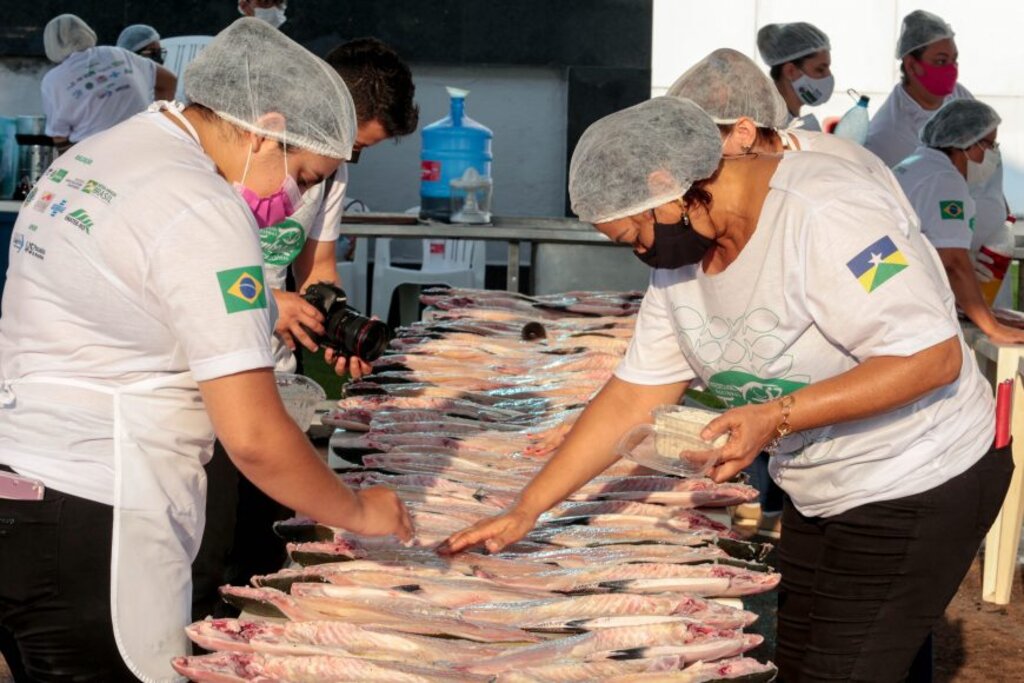 Colaboradores temperam os peixes antes de ir para churrasqueira; trabalho foi divido em equipes - Gente de Opinião