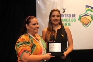 Enfermeira Lucilene Souza recebendo placa em nome do Hospital Central - Gente de Opinião